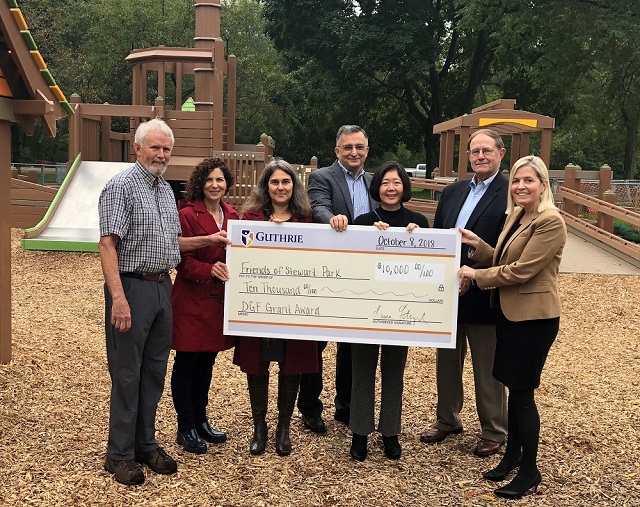 People holding large check on playground