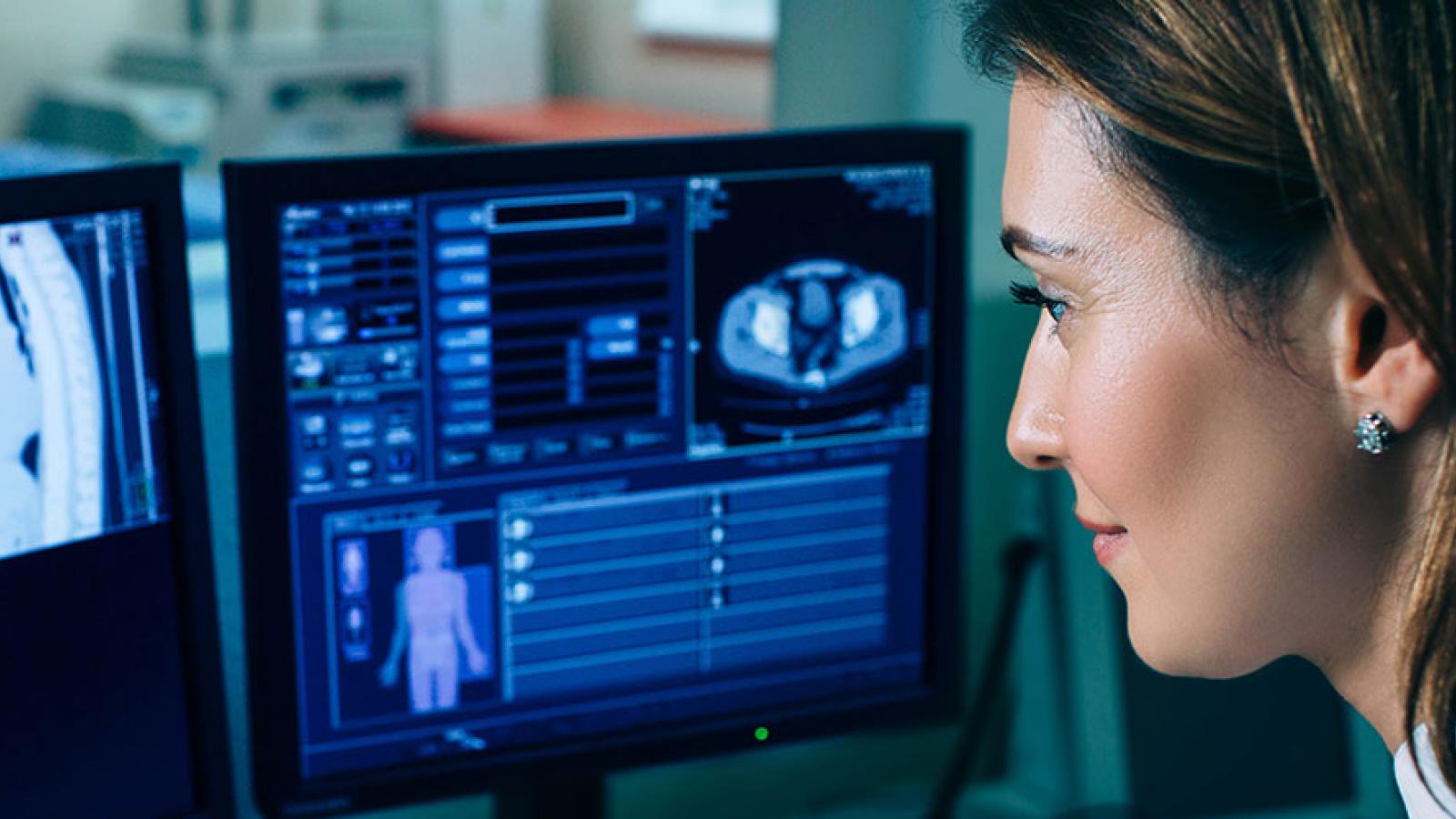 Doctor looking at computers showing body scan images 