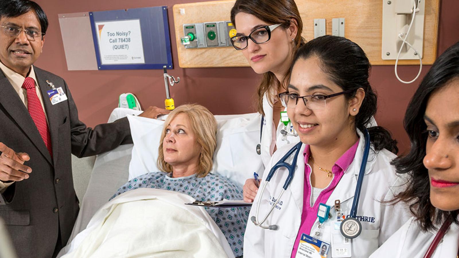 Residents and doctor with patient 