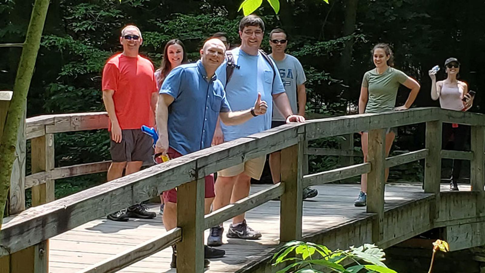 People standing on a bridge in the woods