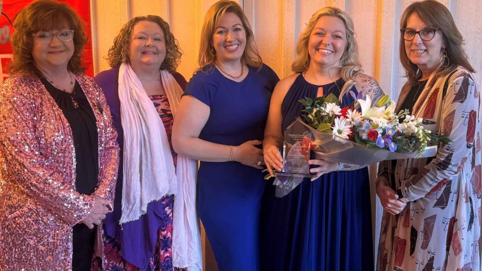 A group of five women pose for a photo.