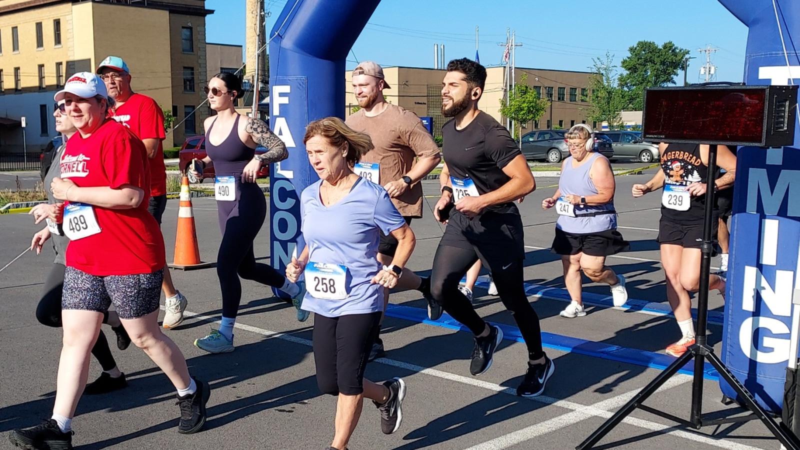 Runners pass under an inflatable arch.