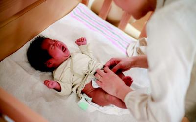 A woman changes a baby's diaper.