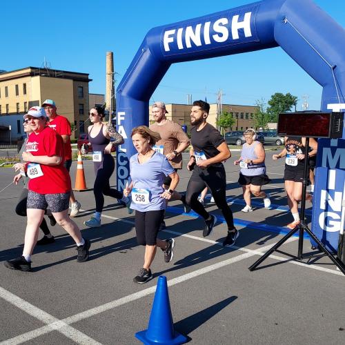 Runners pass under an inflatable arch.